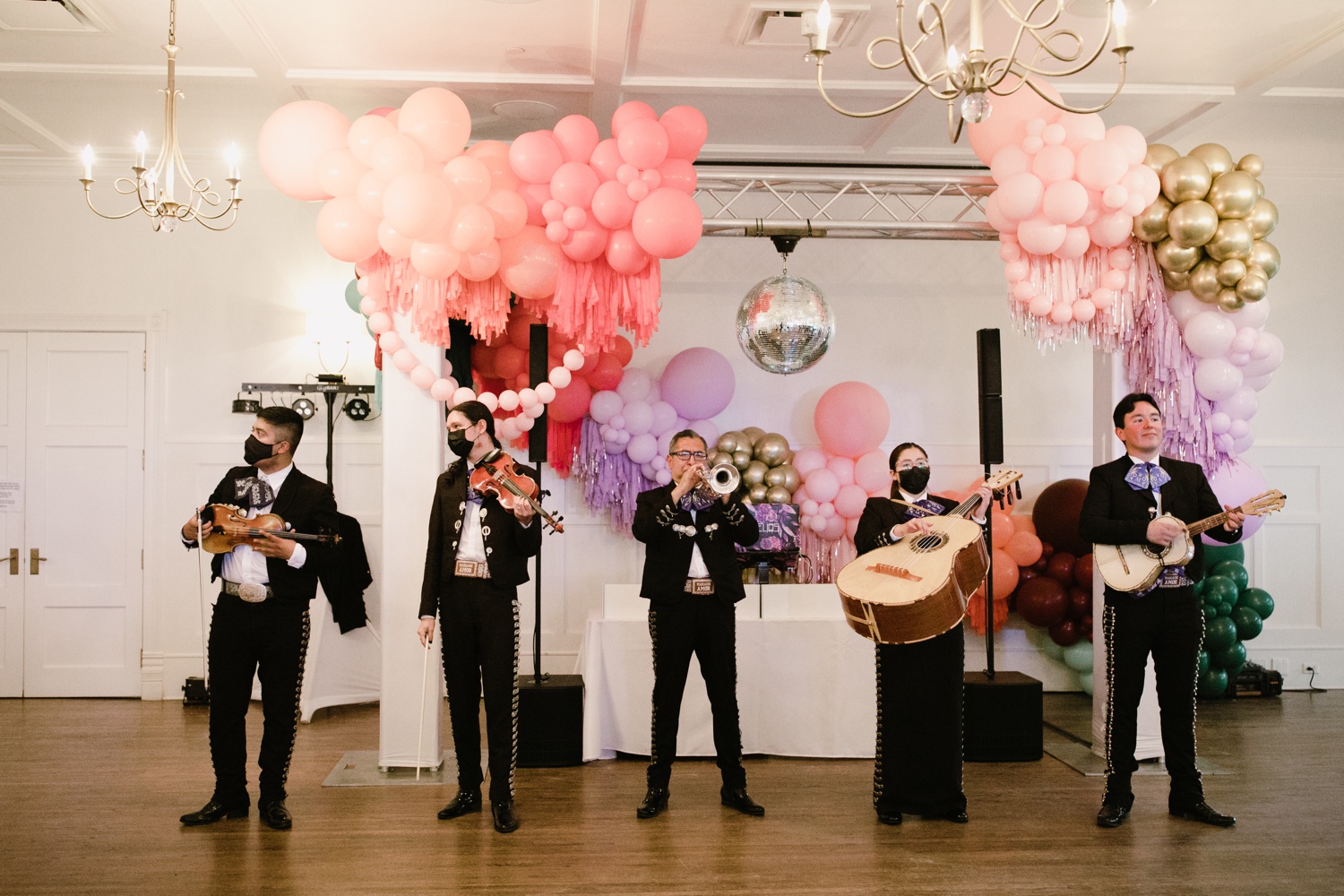 Dance party reception featuring brightly colored balloons, a disco ball, and a mariachi band