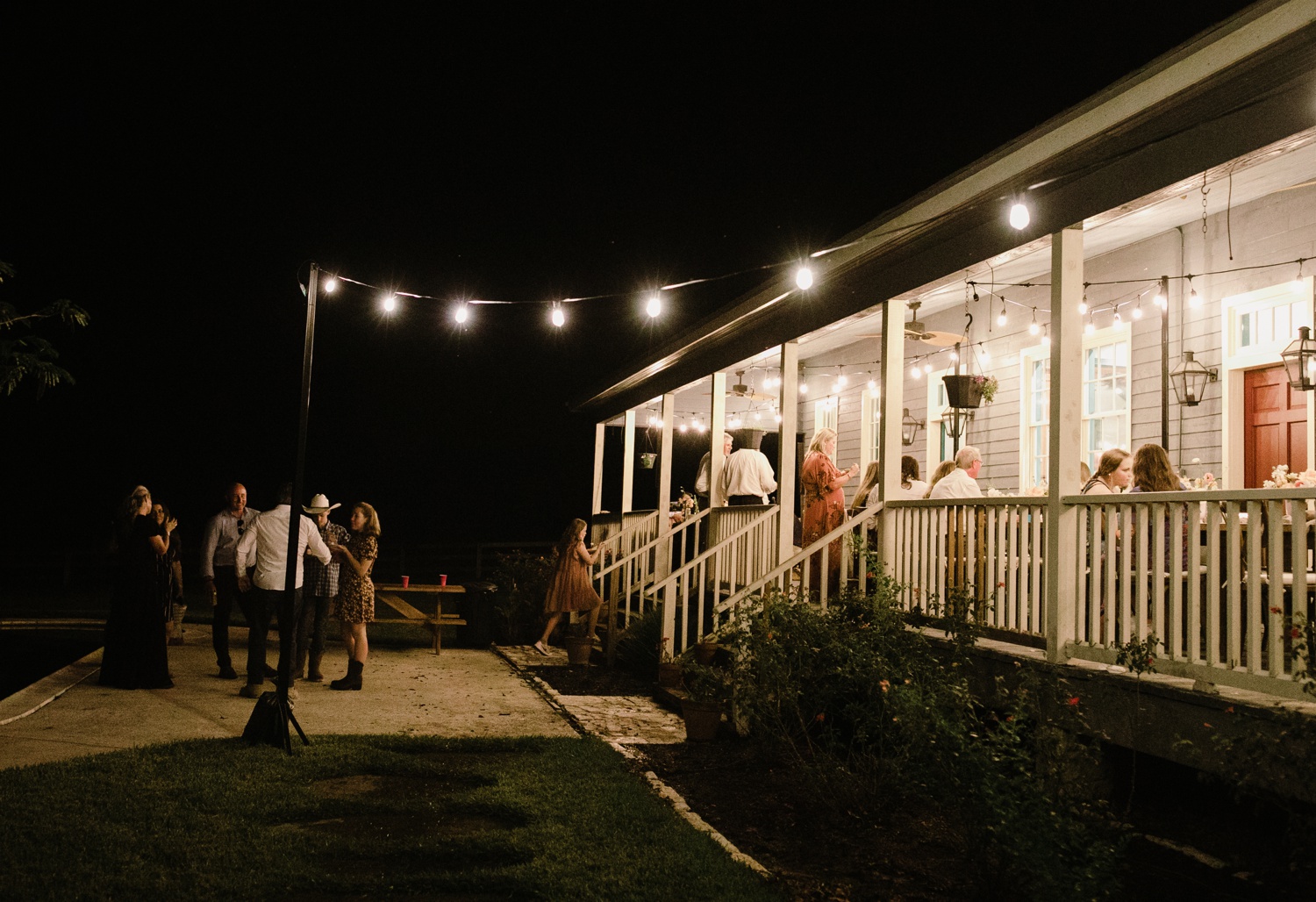 Cafe lights and pink and white flowers for an outdoor sunset wedding reception