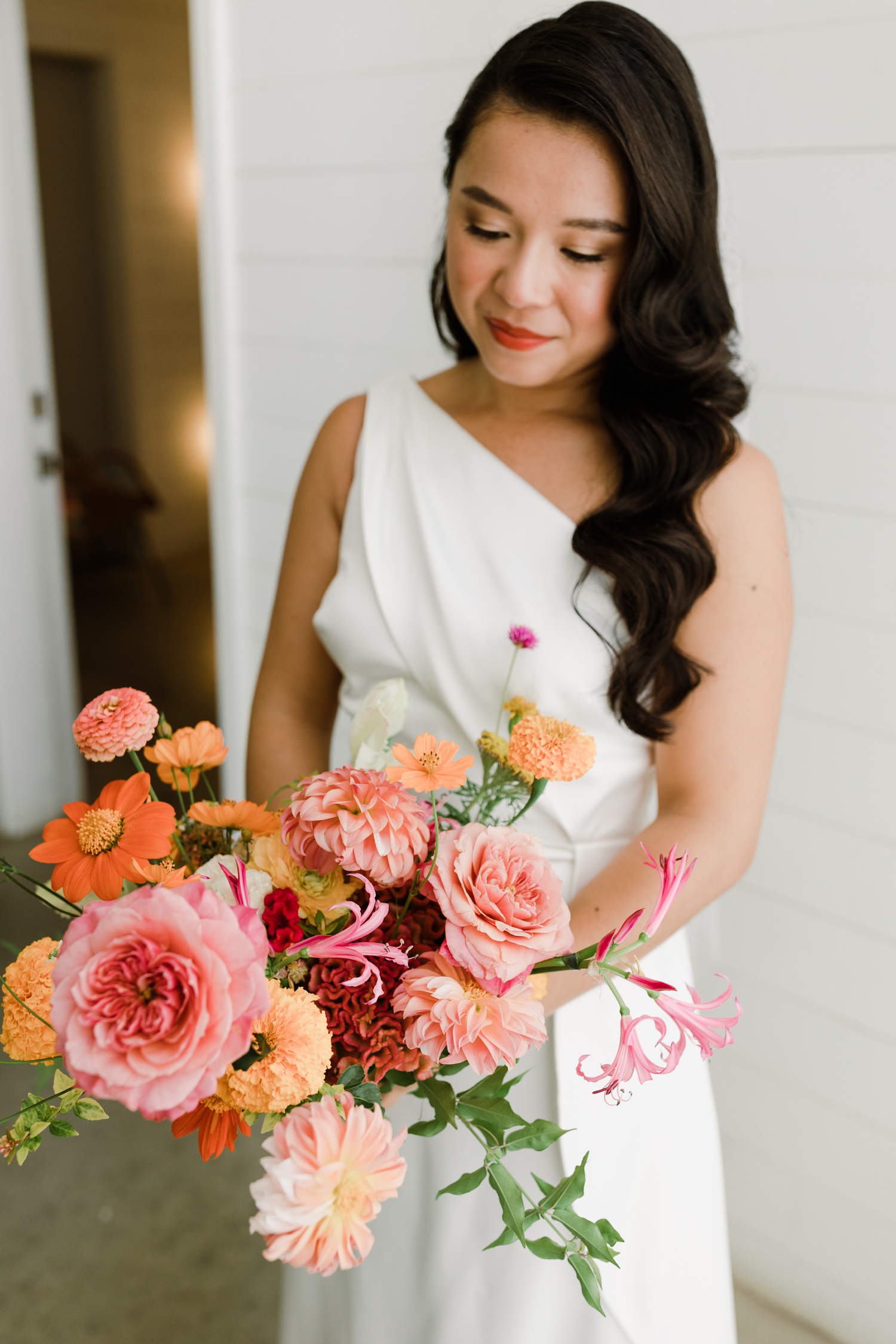 Pink and orange wedding bouquet with dahlias, zinnias, and garden roses by Mountain Laurel Floral