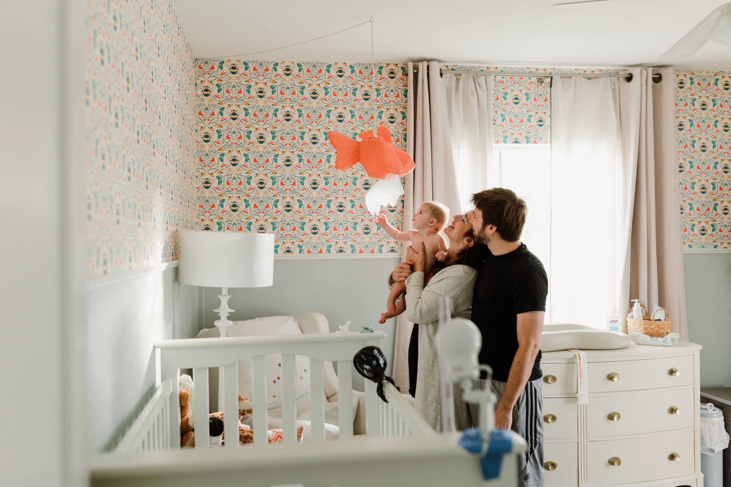 parents with their baby in bee-themed nursery