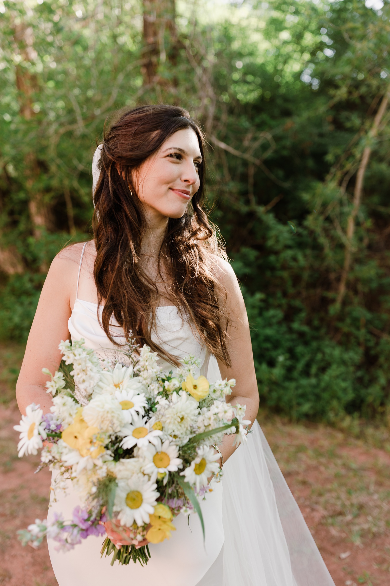 Bridal bouquet filled with daisies, yellow cosmos, and white dahlias