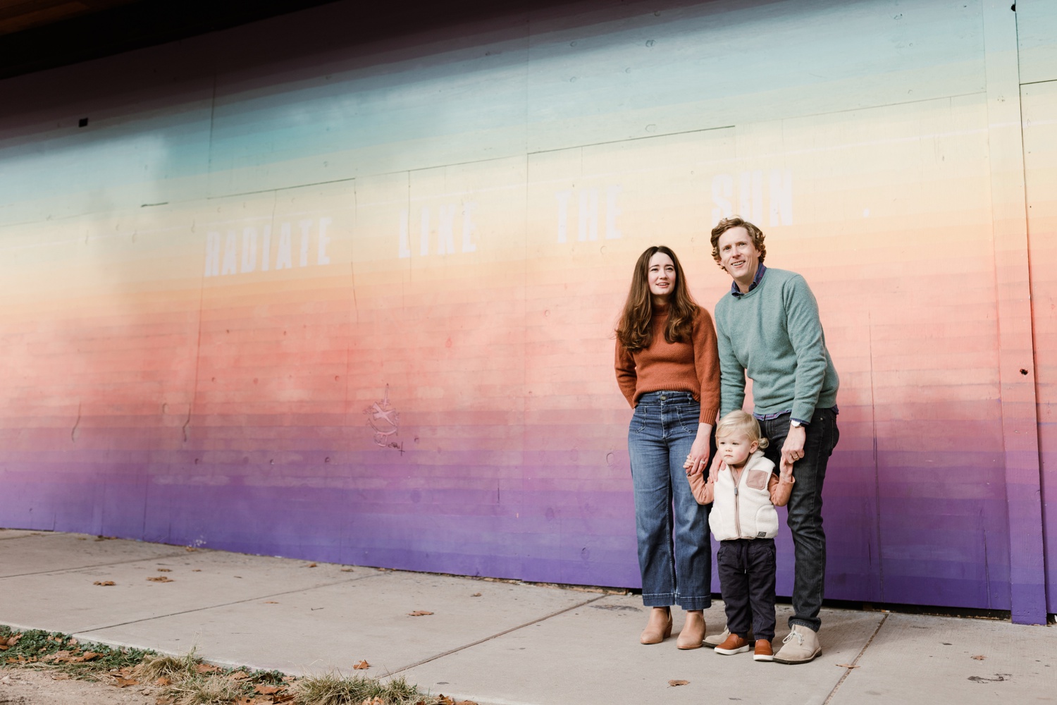 Family posing in front of a street mural in Austin, TX