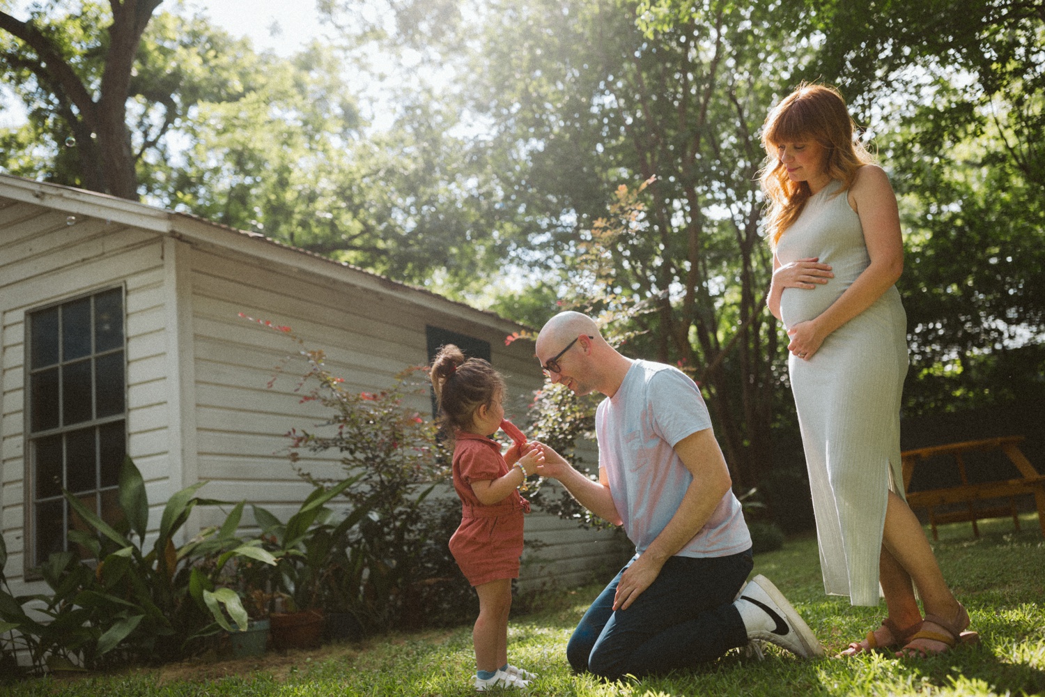 Mom and dad playing with their two-year-old daughter in their backyard