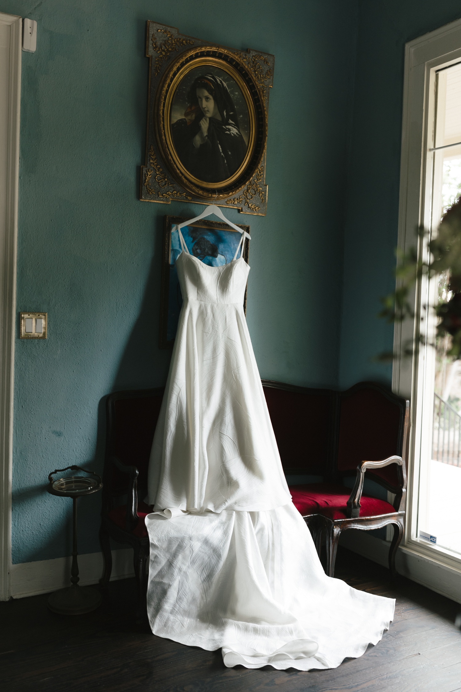 Wedding dress hanging from an antique gilded frame 