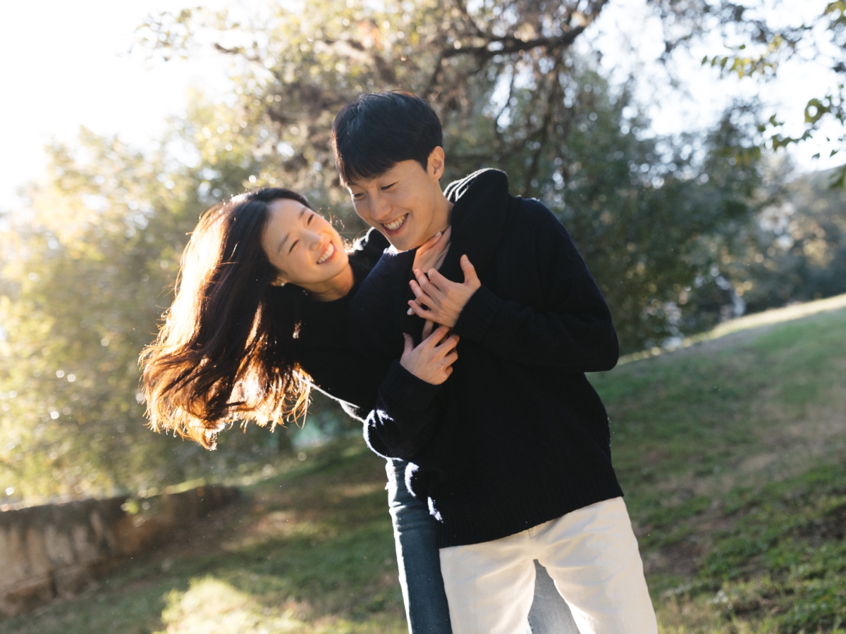 A documentary-style engagement photo of an Asian couple at Lady Bird Lake in Austin, Texas