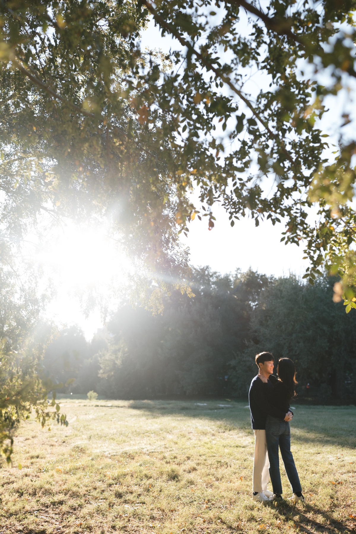 A film photo of an engaged couple in the Lady Bird Lake park at golden hour