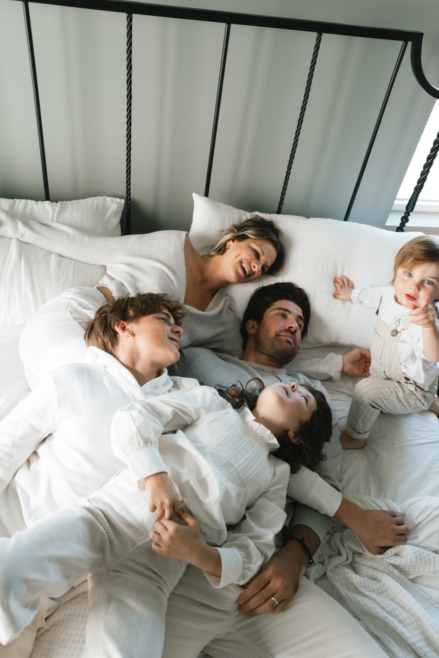 family piled on bed during photo session