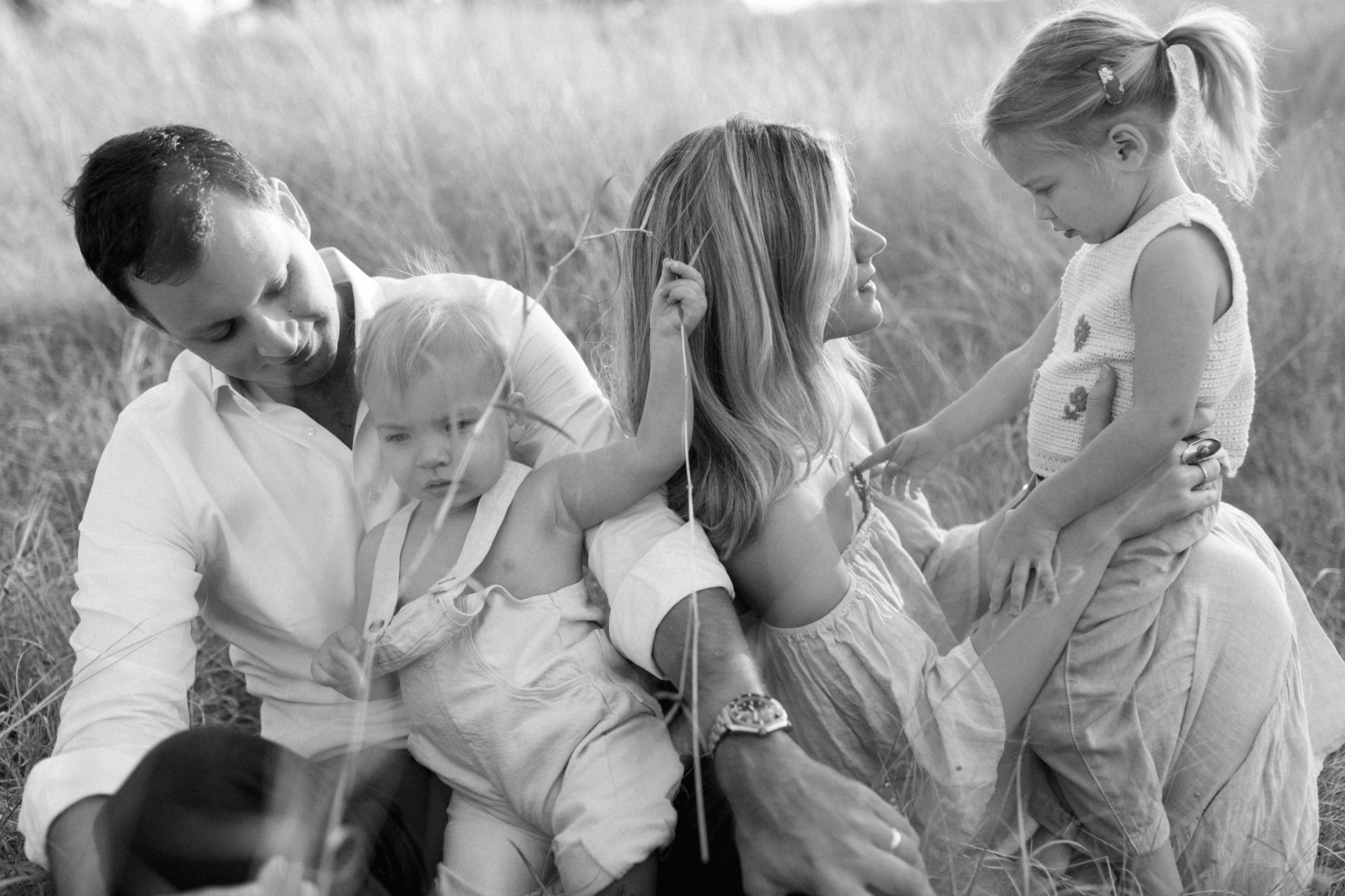 Candid family photos in a field at sunset 