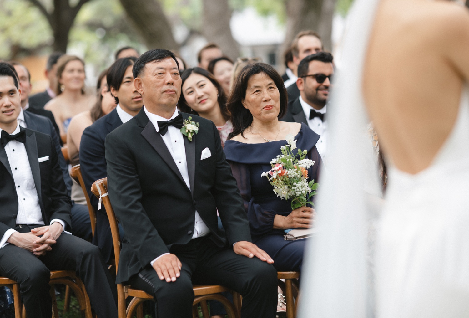 Parents of the bride watching her during her wedding ceremony