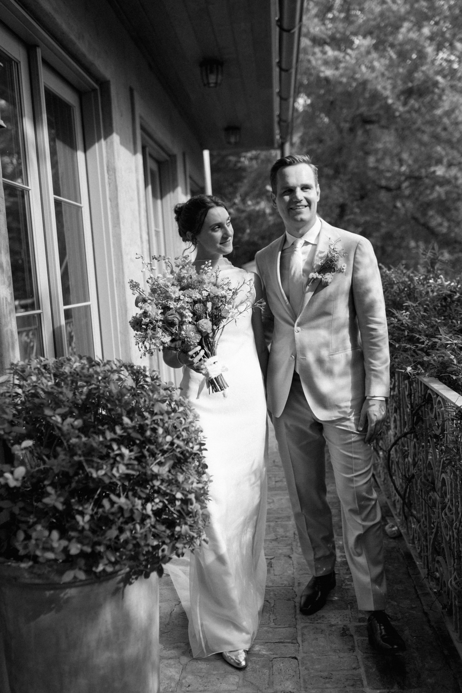 Black and white portrait of a bride and groom on a balcony at The Inn at Jennifer's Gardens