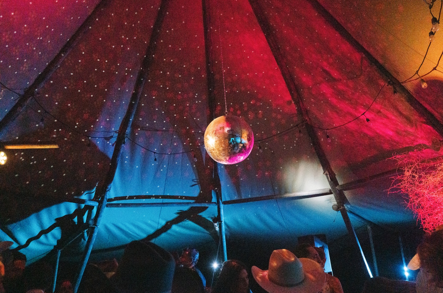 Disco ball hanging from a tent ceiling at a Marfa, TX wedding