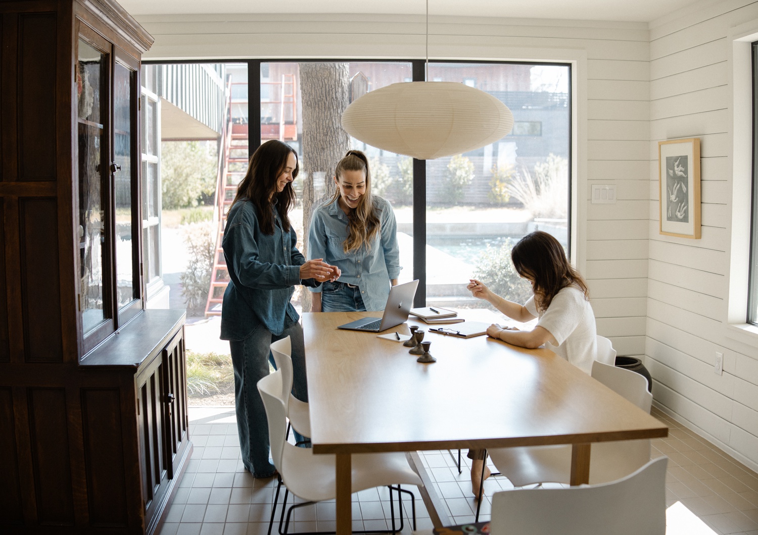 Female coworkers around a table with laptop and notebooks