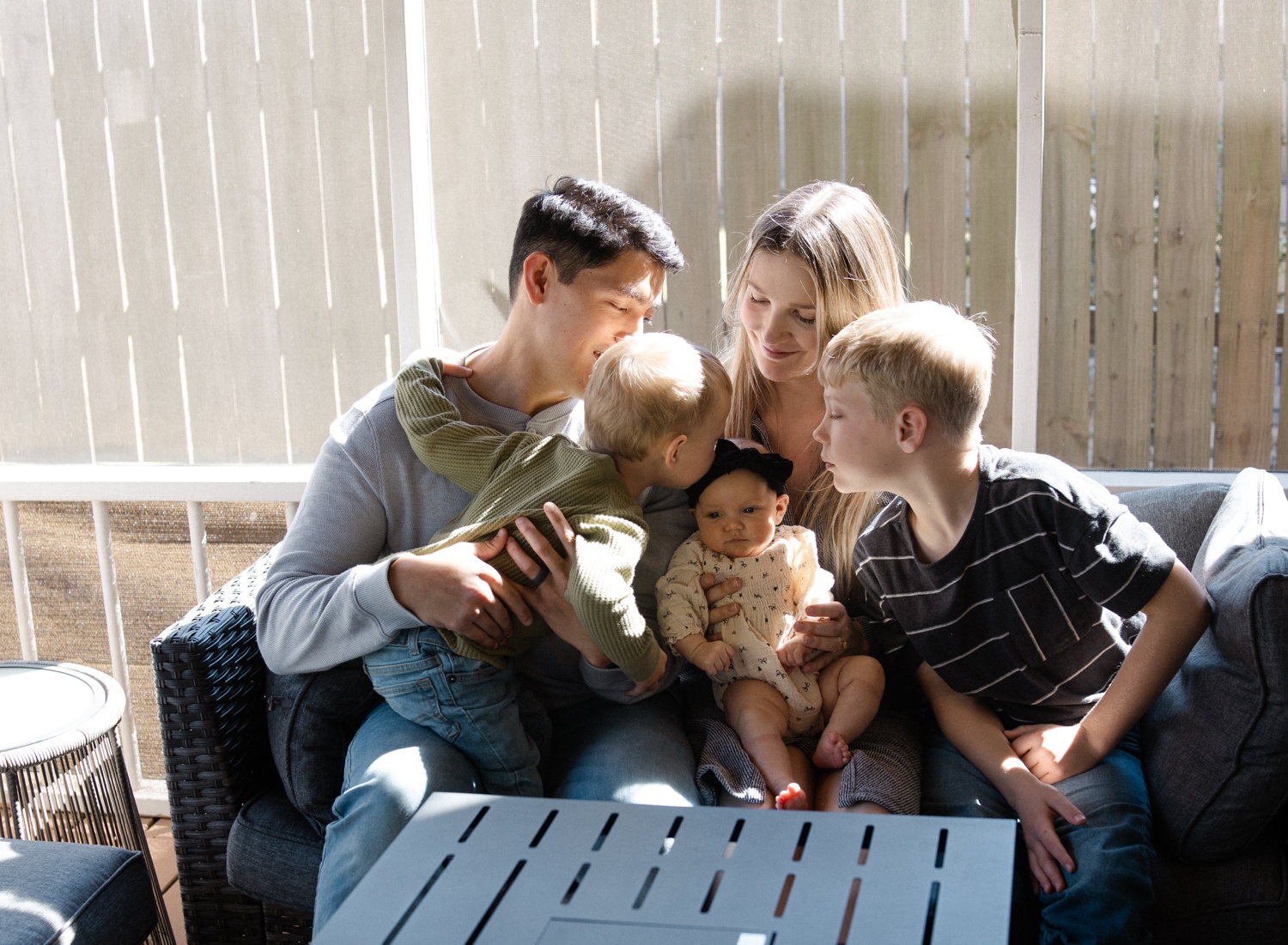 Family relaxing on back porch during Austin maternity and newborn bundle session