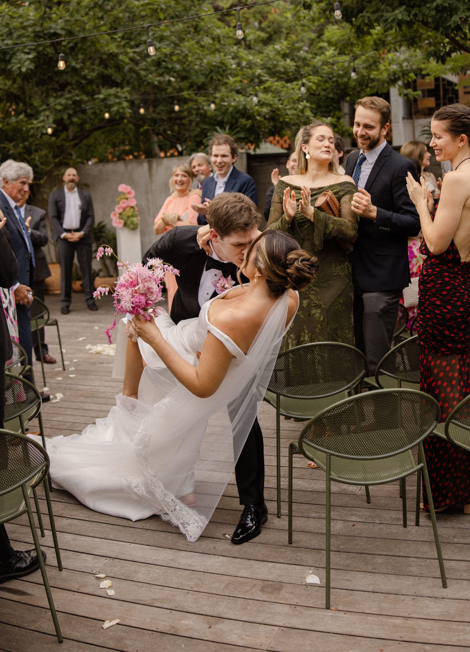 Groom dipping bride for a kiss after their wedding ceremony